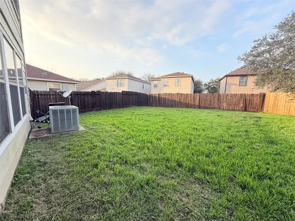 a view of a backyard with potted plants and wooden fence
