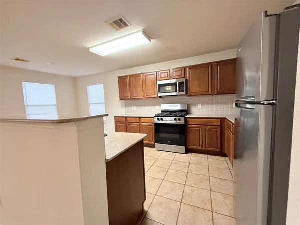 a kitchen with stainless steel appliances a refrigerator a stove a sink and a refrigerator