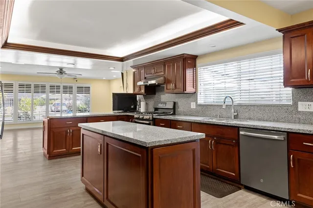 a kitchen with stainless steel appliances granite countertop a sink stove and cabinets
