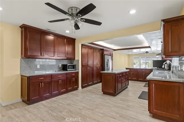 a kitchen with stainless steel appliances granite countertop wooden cabinets a stove top oven a sink and dishwasher