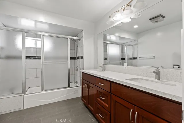 a bathroom with a double vanity sink mirror and shower