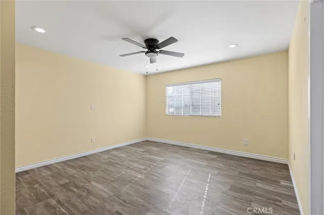 a view of a big room with wooden floor and a ceiling fan