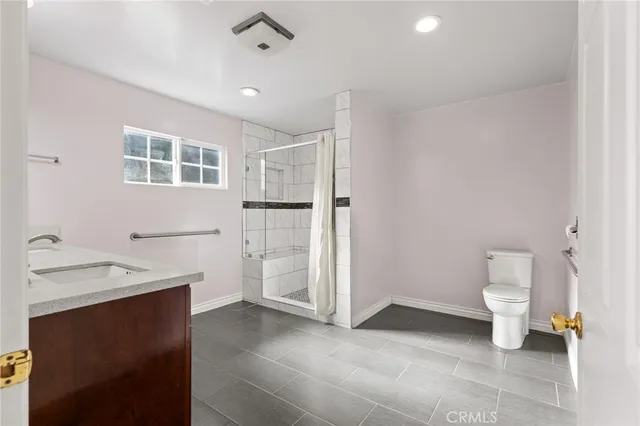 a bathroom with a granite countertop double vanity sink and a mirror