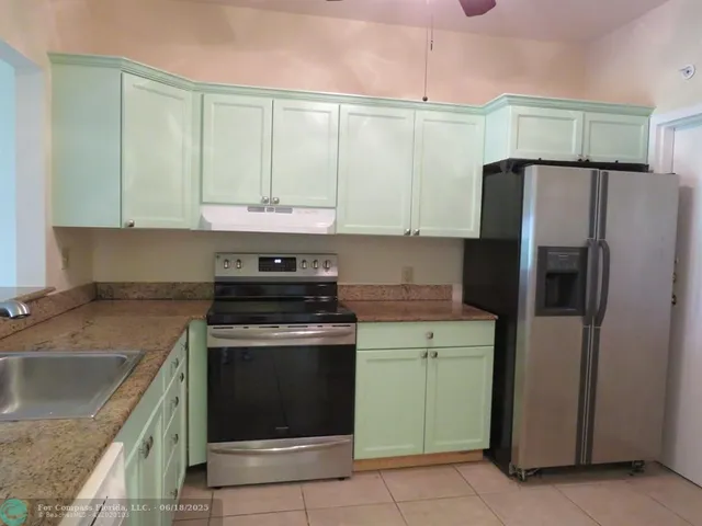 a kitchen with a stove a sink and a refrigerator