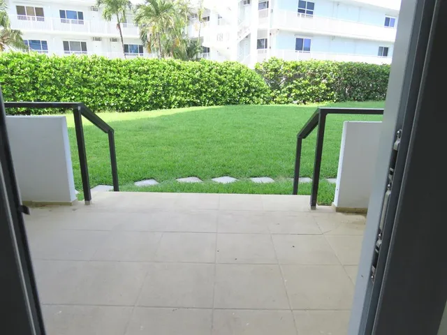 a front view of a house with a yard and potted plants