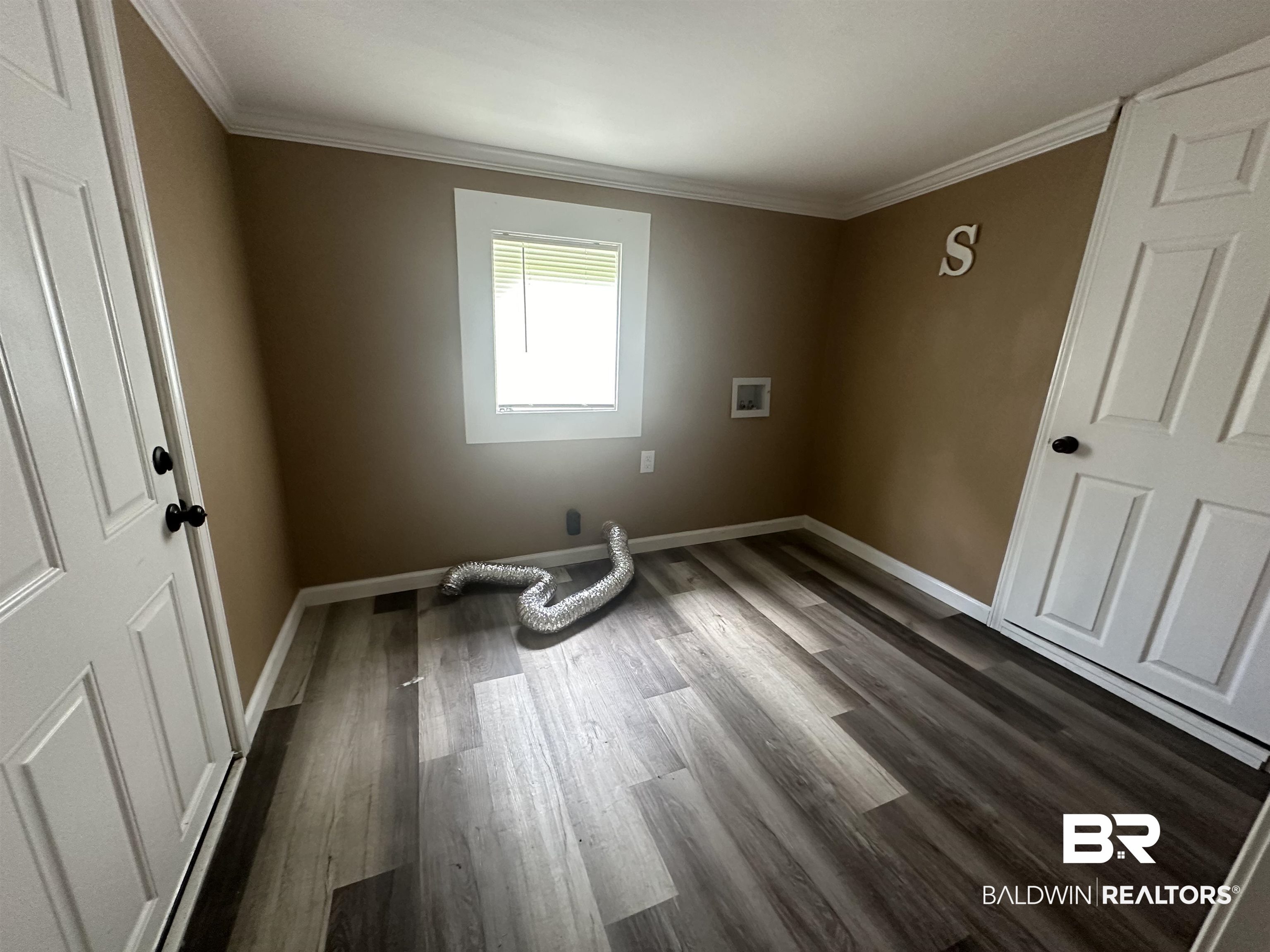 1600 Woods Road Atmore, AL 36502 - Photo 11 of 20 Unfurnished room featuring dark wood-type flooring and crown molding