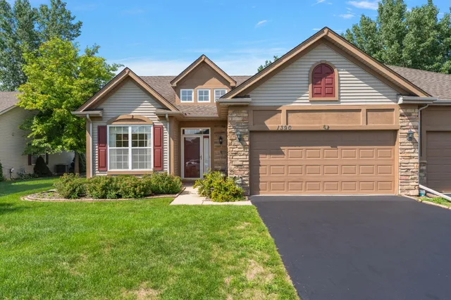 a front view of a house with a garden and plants