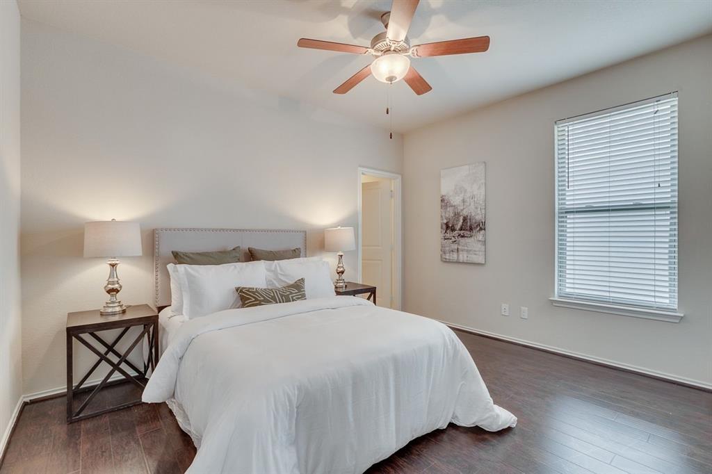 2701 McCart Avenue, Unit 101 Fort Worth, TX 76110 - Photo 19 of 21 a bedroom with a large bed and a ceiling fan
