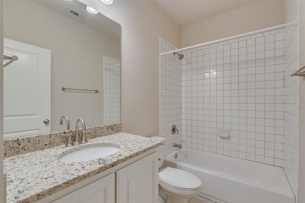 2701 McCart Avenue, Unit 101 Fort Worth, TX 76110 - Photo 20 of 21 a bathroom with a granite countertop sink toilet and shower