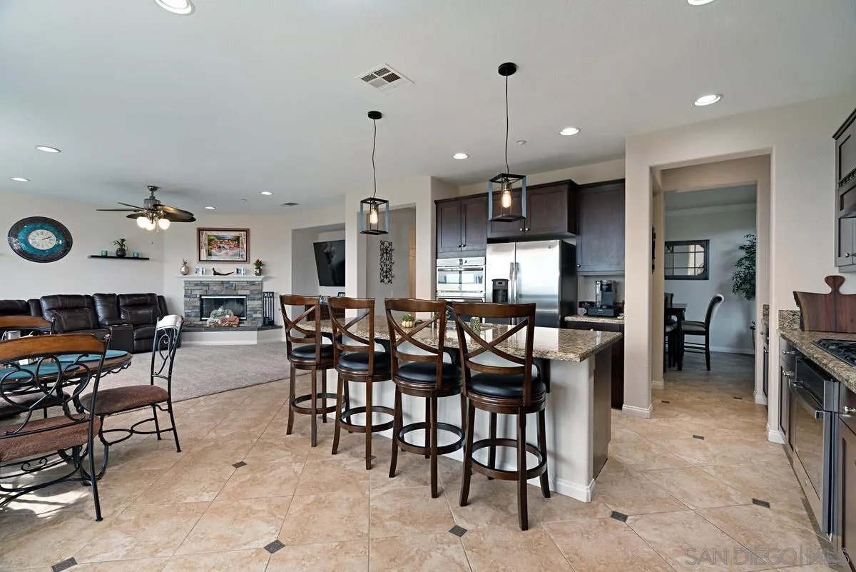 10689 Laurel Path Escondido, CA 92026 - Photo 15 of 48 a dinning area with stainless steel appliances kitchen island granite countertop a table and chairs