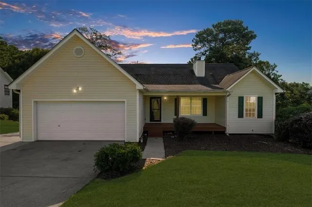 a front view of a house with a garden and yard