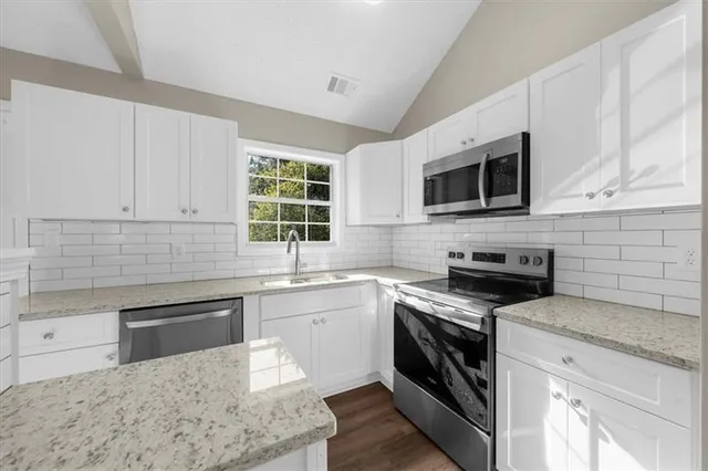 a kitchen with a sink stove and cabinets