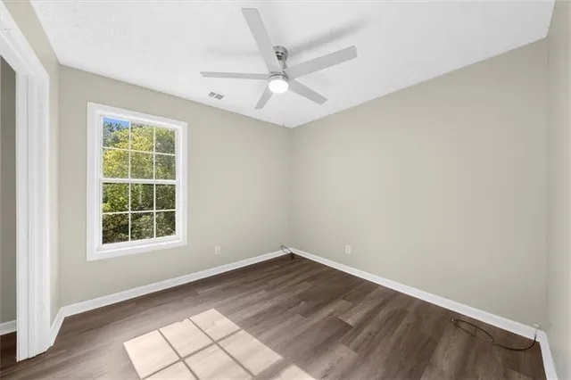 a view of empty room with wooden floor