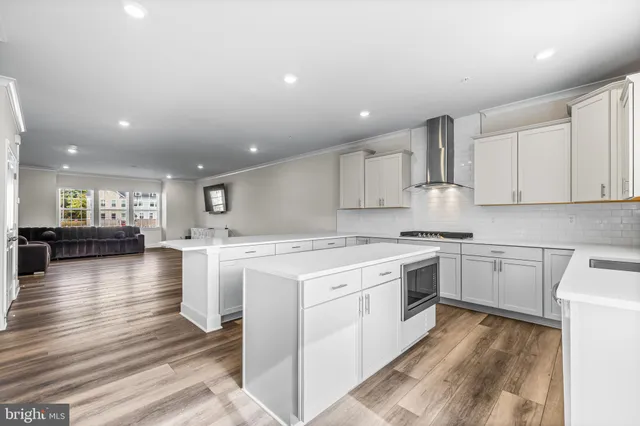 a kitchen with a stove top oven and white cabinets