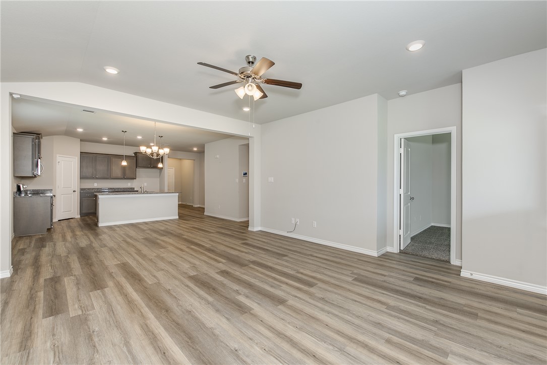 2166 Chief Street Bryan, TX 77807 - Photo 4 of 18 a view of a big room with wooden floor and a kitchen