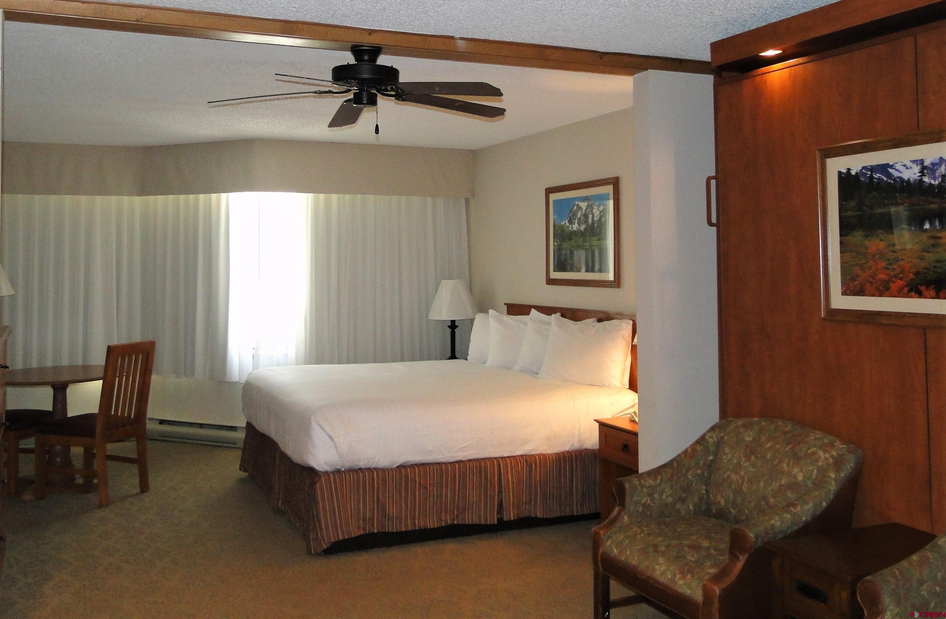 6 Emmons Road, Unit 122 Crested Butte, CO 81225 - Photo 16 of 19 a bedroom with a bed a couch and a chandelier