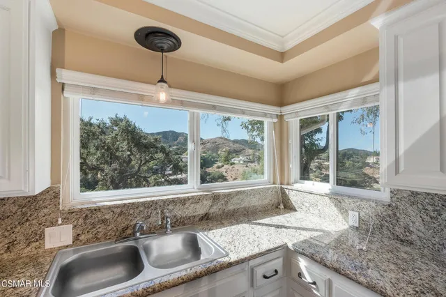 a kitchen with a stove a refrigerator and a sink with wooden floor