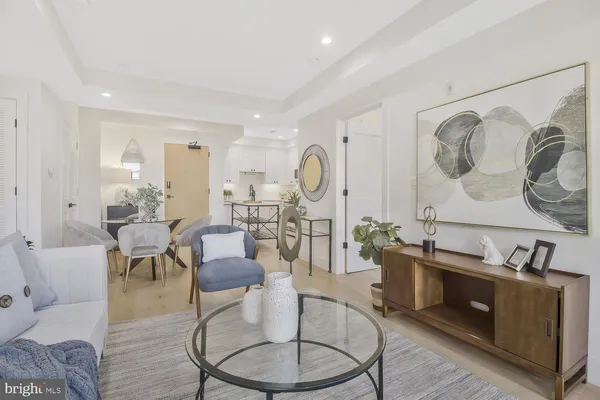 a living room with furniture a table and wooden floor