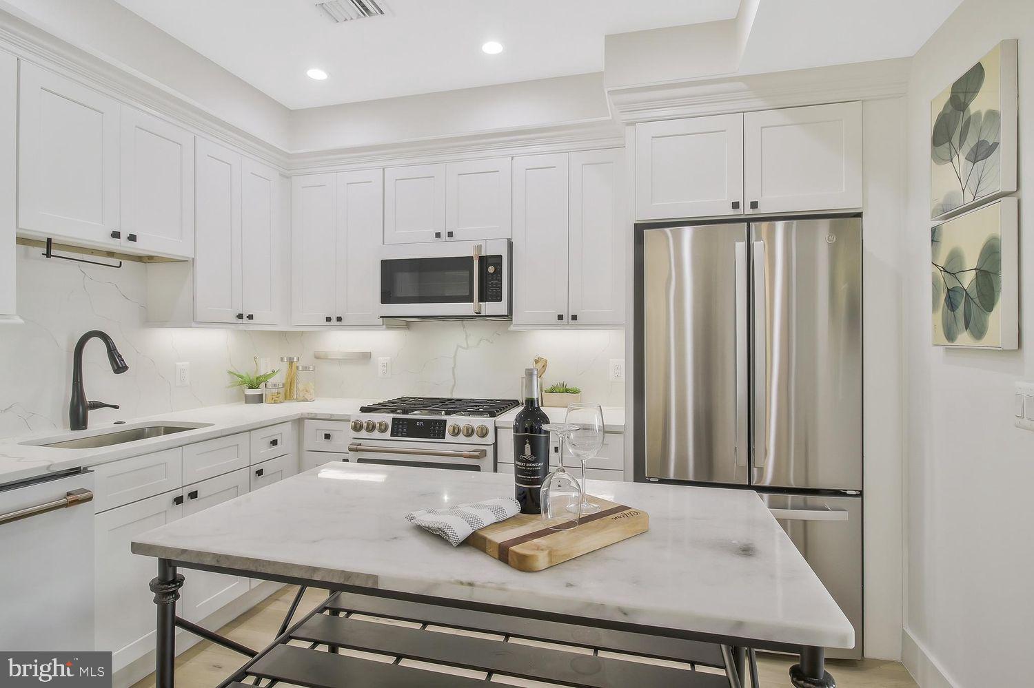 1654 K Street Northeast, Unit 8 Washington, DC 20002 - Photo 5 of 20 a kitchen with stainless steel appliances a stove a sink a refrigerator and cabinets