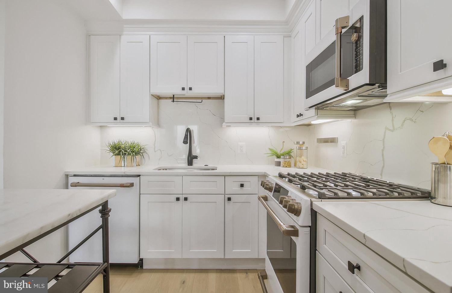 1654 K Street Northeast, Unit 8 Washington, DC 20002 - Photo 7 of 20 a kitchen with stainless steel appliances a white cabinets and a stove top oven