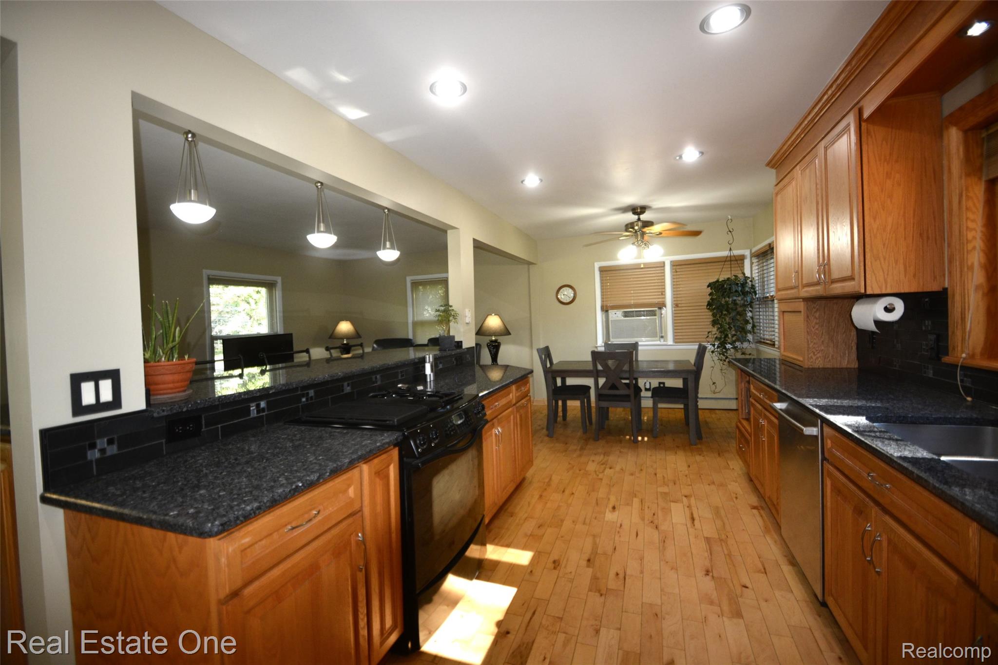 615 Willard Avenue Rochester, MI 48307 - Photo 9 of 30 Spacious kitchen featuring wood-finish flooring, dark speckled countertops, and wood cabinetry