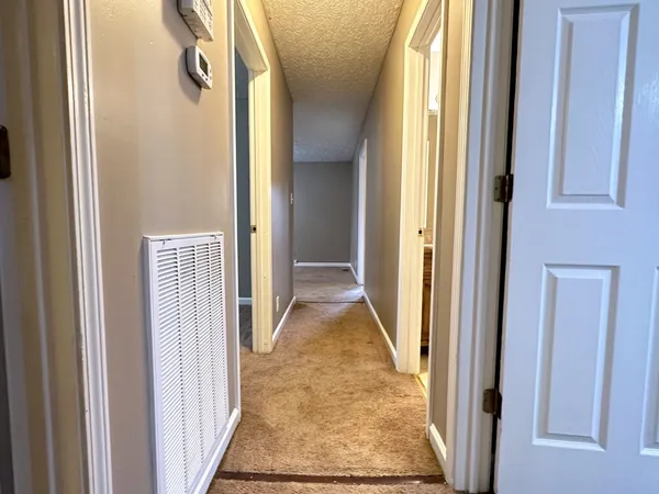 a view of a hallway with wooden floor and glass door