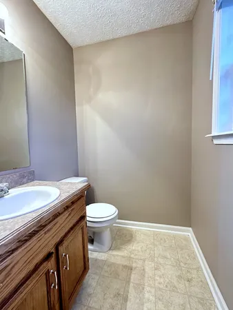 a bathroom with a granite countertop toilet and a sink