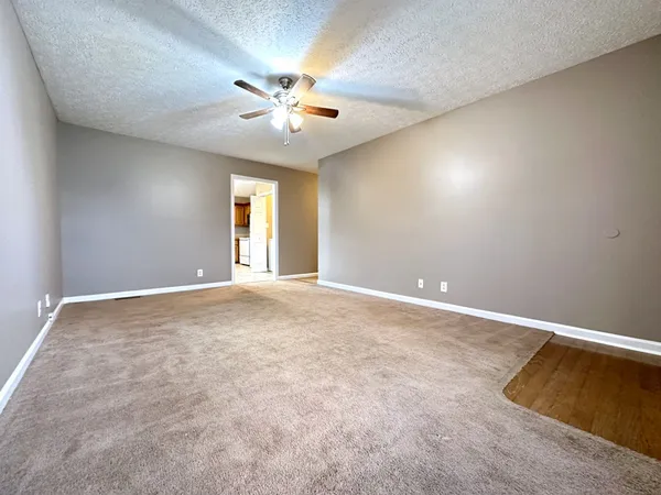 an empty room with chandelier fan