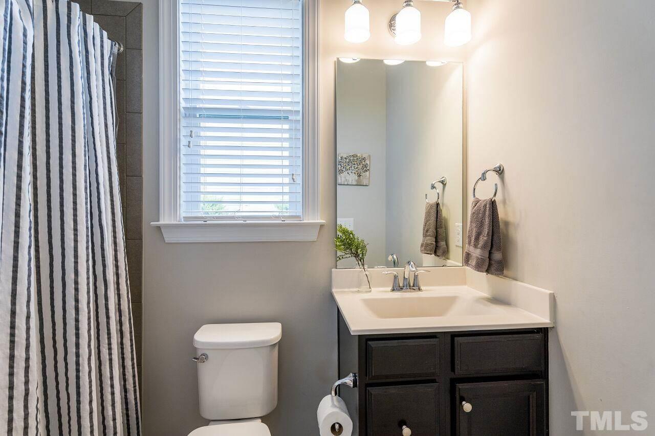 5264 Aleppo Lane Raleigh, NC 27613 - Photo 17 of 30 Downstairs full guest bathroom features tiled shower and floors.