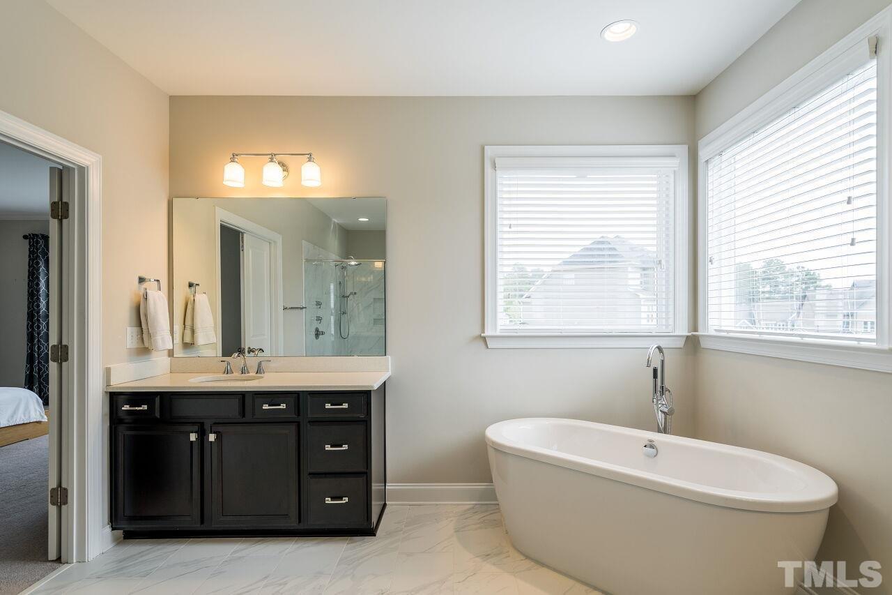 5264 Aleppo Lane Raleigh, NC 27613 - Photo 20 of 30 Soaking tub with freestanding faucet, separate sink vanities, subway tiled shower, separate water closet, and huge walk in closet that leads to laundry room.