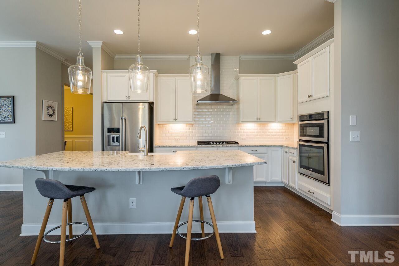 5264 Aleppo Lane Raleigh, NC 27613 - Photo 7 of 30 Modern range hood and built in oven and microwave make using this chef's kitchen a dream.