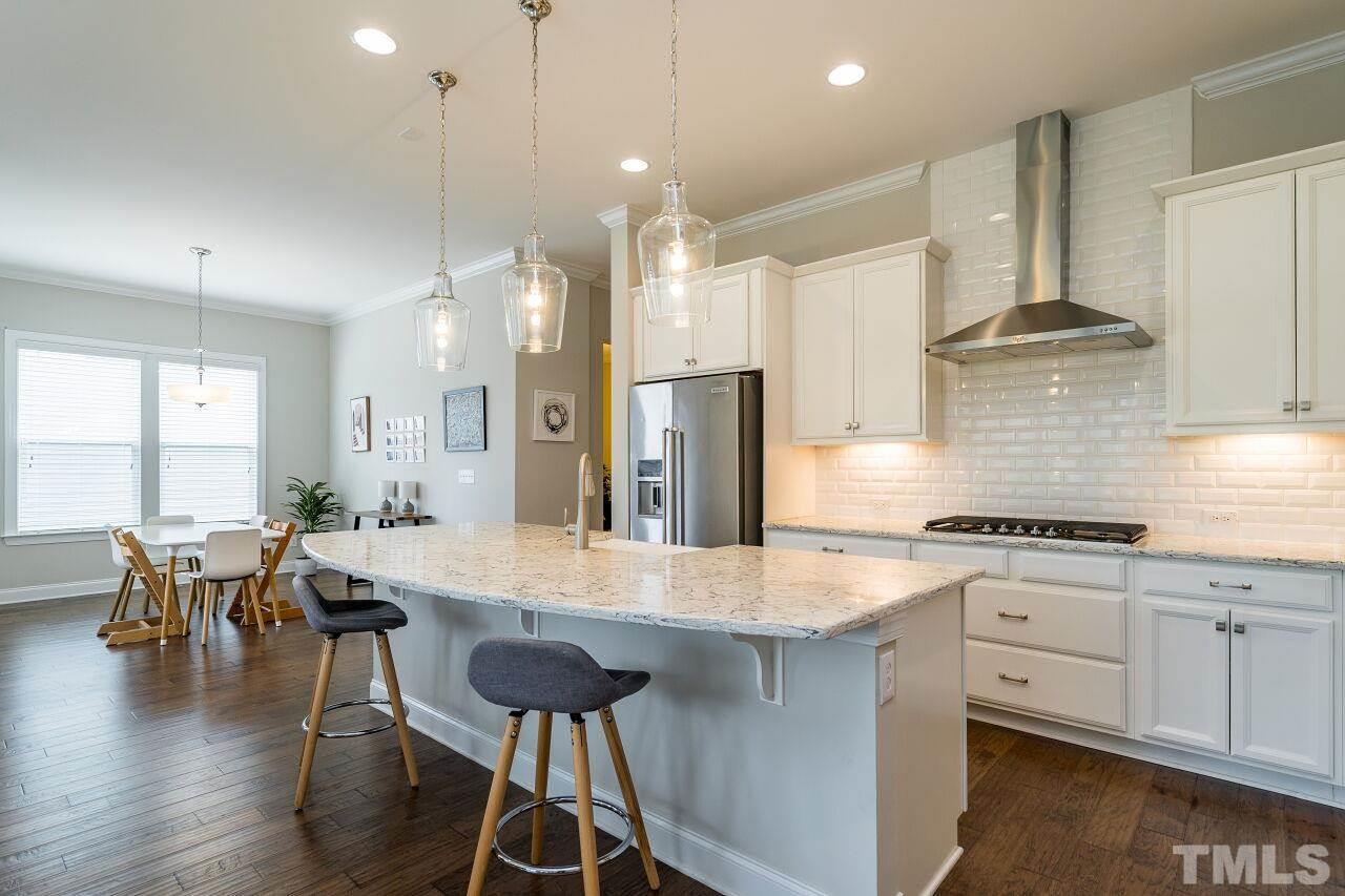 5264 Aleppo Lane Raleigh, NC 27613 - Photo 8 of 30 Recessed lighting and island pendants give a glow to this show-stopping kitchen in the heart of the home.