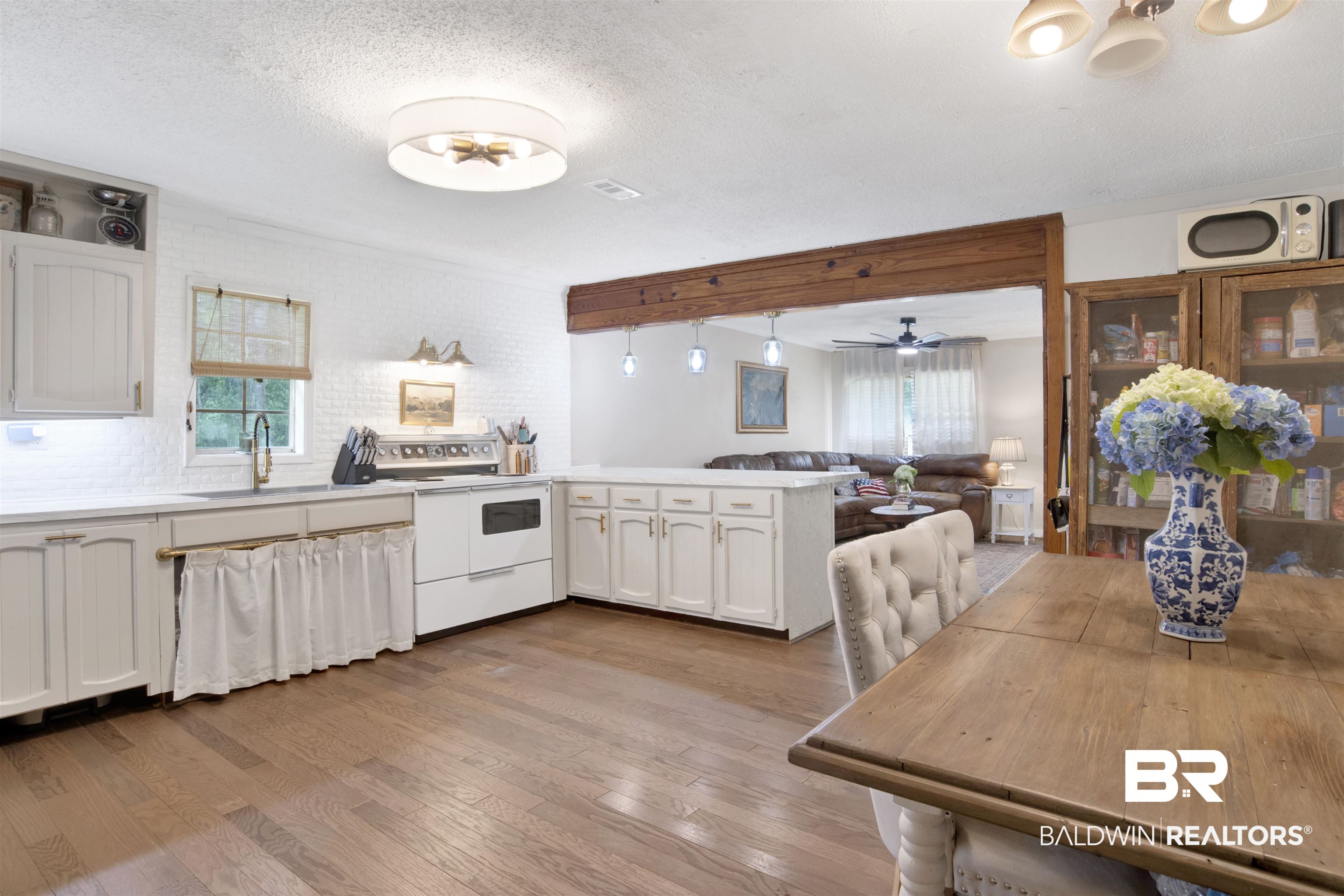 4265 Greaves Road Eight Mile, AL 36613 - Photo 33 of 34 Kitchen featuring white electric range, a peninsula, wood finished floors, open floor plan, and a textured ceiling