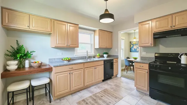 a kitchen with granite countertop a sink counter top space appliances and cabinets