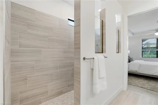 a spacious en suite bathroom with a double sink and mirror