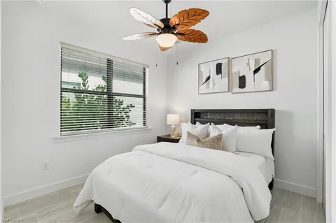 a bedroom with a bed and a lamp on a dresser