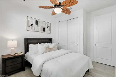 a bedroom with a bed mirror and window