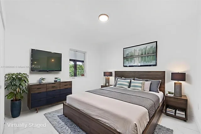 a bedroom with a bed and a flat screen tv