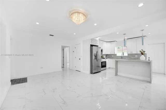 a kitchen with granite countertop white cabinets white stainless steel appliances and a sink