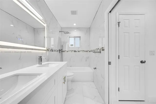 a bathroom with a granite countertop sink a mirror and a shower