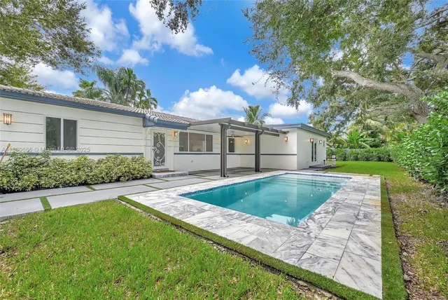 a view of a house with backyard and sitting area