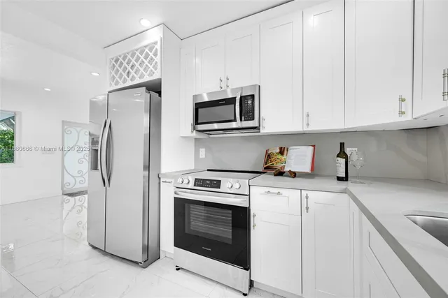 a kitchen with stainless steel appliances white cabinets and a refrigerator