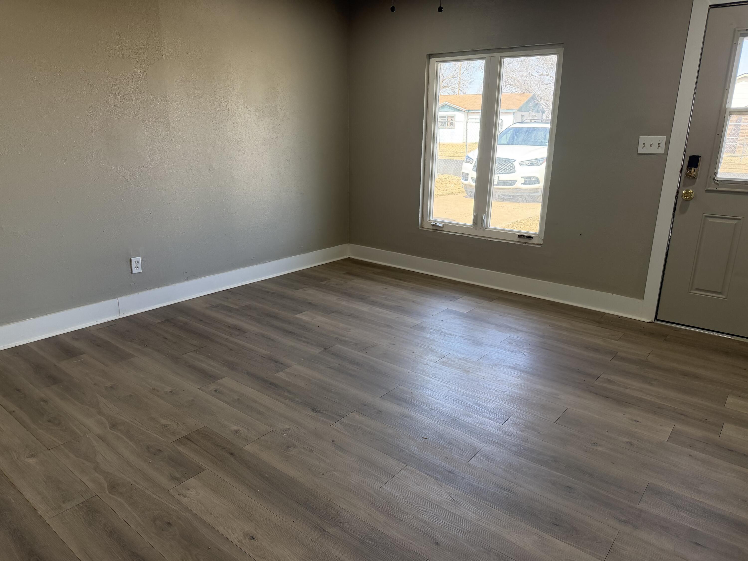 2906 Beech Avenue Lubbock, TX 79404 - Photo 2 of 10 an empty room with wooden floor and windows