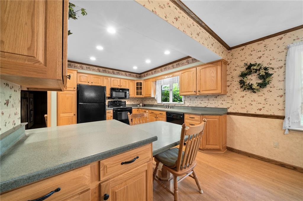 338 Hellein School Road Donegal, PA 15628 - Photo 17 of 46 a kitchen with stainless steel appliances kitchen island granite countertop a refrigerator a stove a sink a dining table and chairs with wooden floor