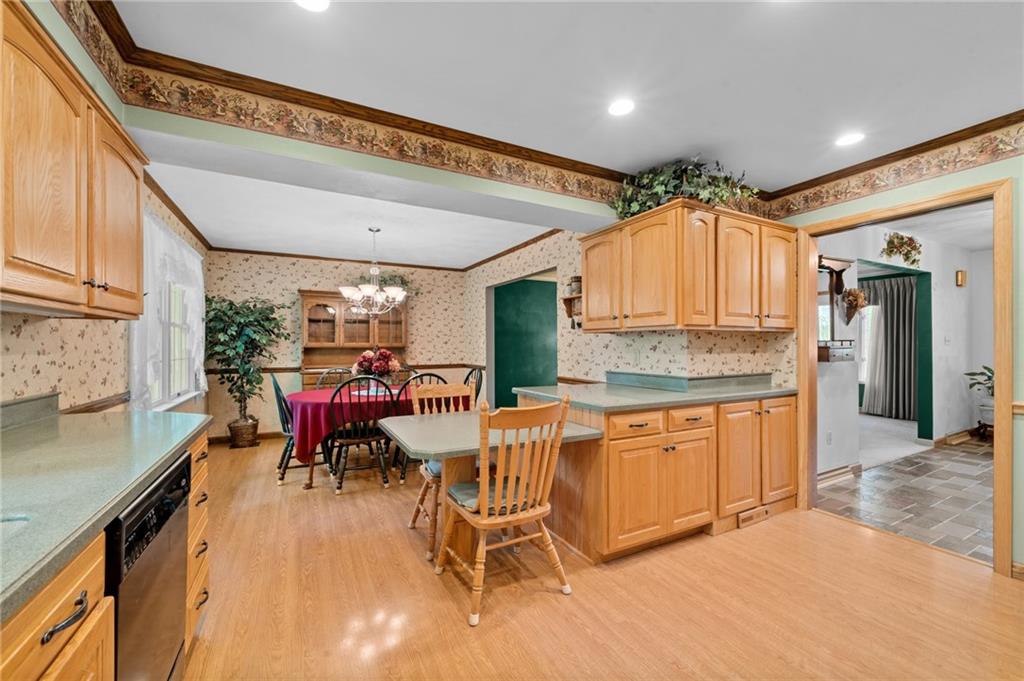 338 Hellein School Road Donegal, PA 15628 - Photo 19 of 46 a kitchen with stainless steel appliances kitchen island granite countertop a table chairs in it and wooden floors