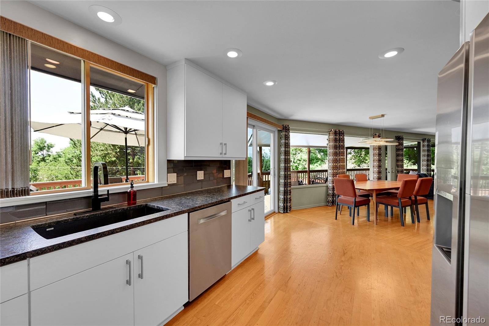 1500 West Ridge Road Littleton, CO 80120 - Photo 11 of 49 a very nice looking dining room with kitchen island a large window cabinets and dining table