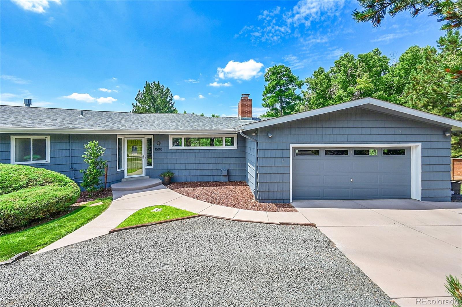 1500 West Ridge Road Littleton, CO 80120 - Photo 2 of 49 a front view of a house with a yard and garage