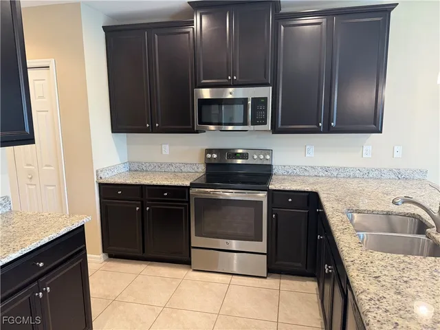 a kitchen with stainless steel appliances granite countertop a sink stove and microwave