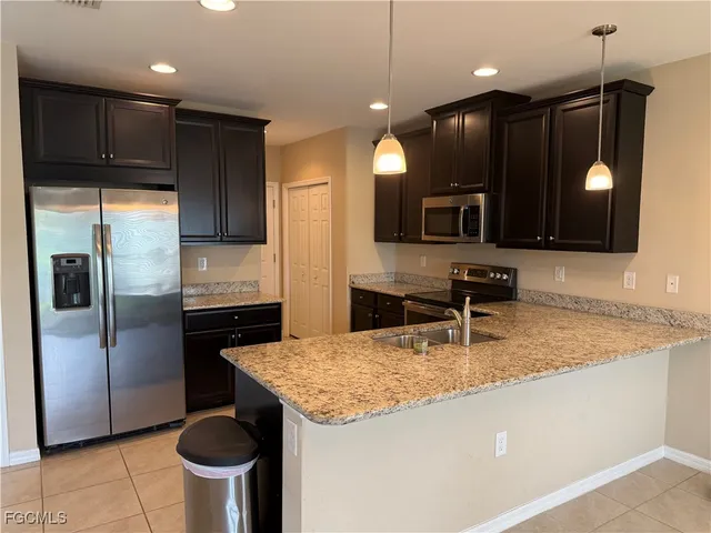 a kitchen with stainless steel appliances granite countertop a sink a stove and a refrigerator