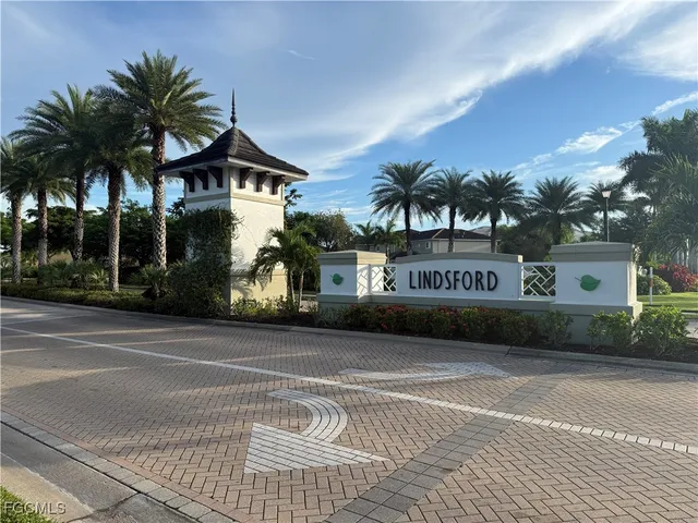 a front view of multi story residential apartment building with yard and sign board
